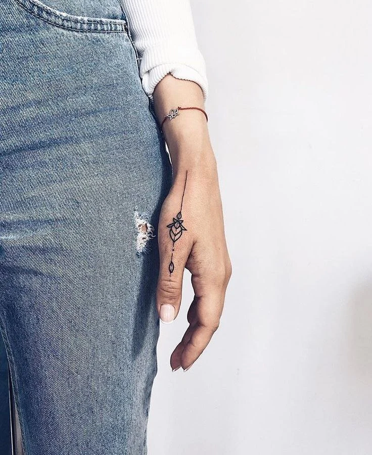 a close up of a hand with finger tattoo
